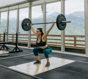 Mulher treinando musculação em academia com vista panorâmica, destacando os benefícios da creatina para o desempenho físico.
