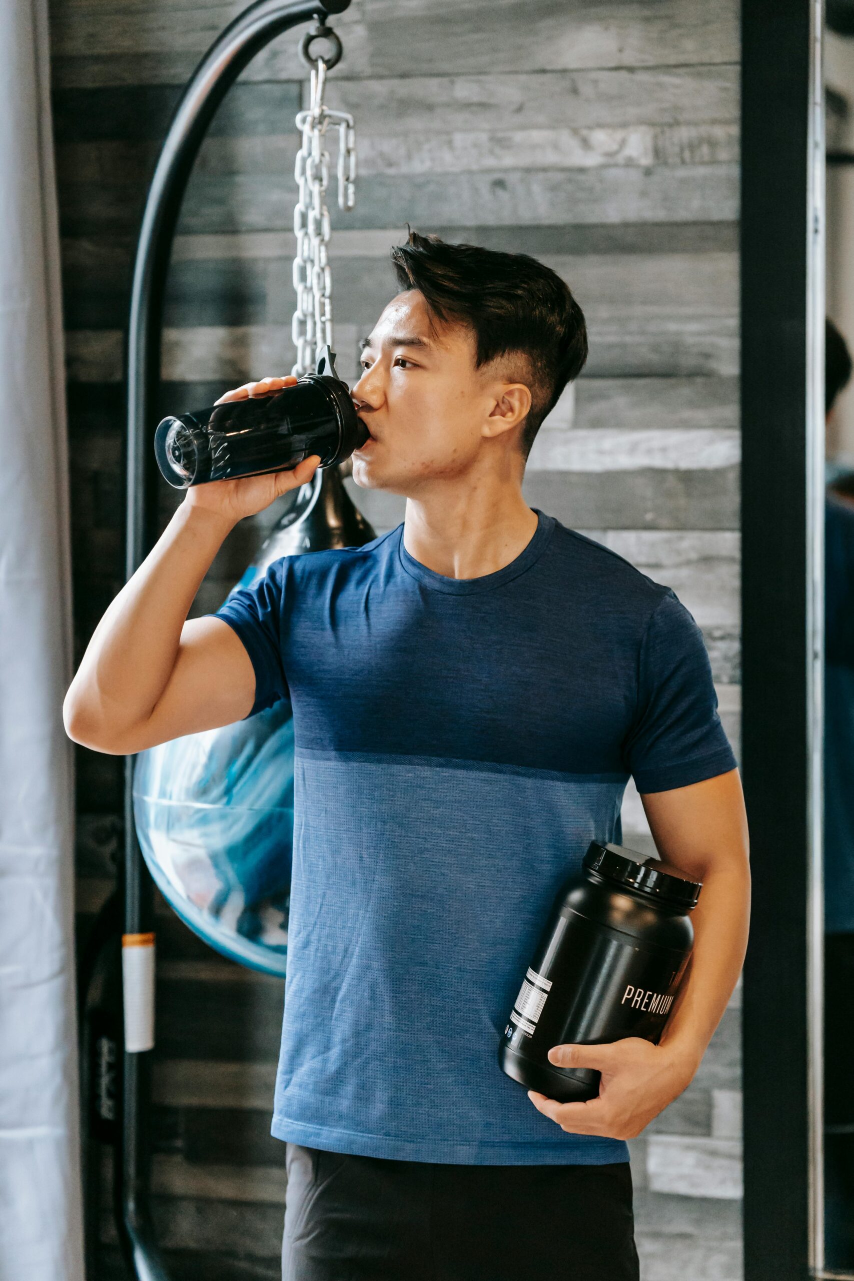 Homem consumindo Whey Protein após o treino para melhorar a recuperação muscular e aumentar a massa.