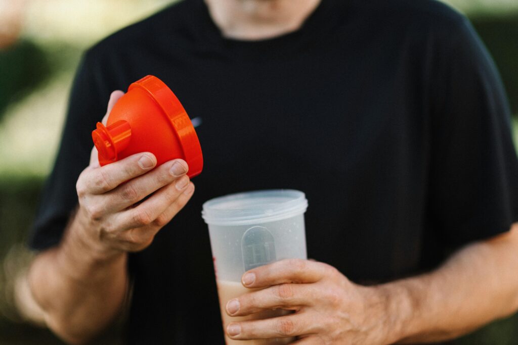 Pessoa preparando shake de Whey Protein para o pós-treino.