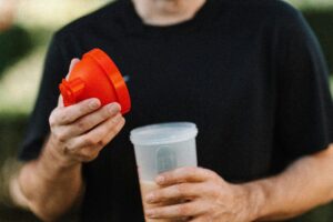 Pessoa preparando shake de Whey Protein para o pós-treino.