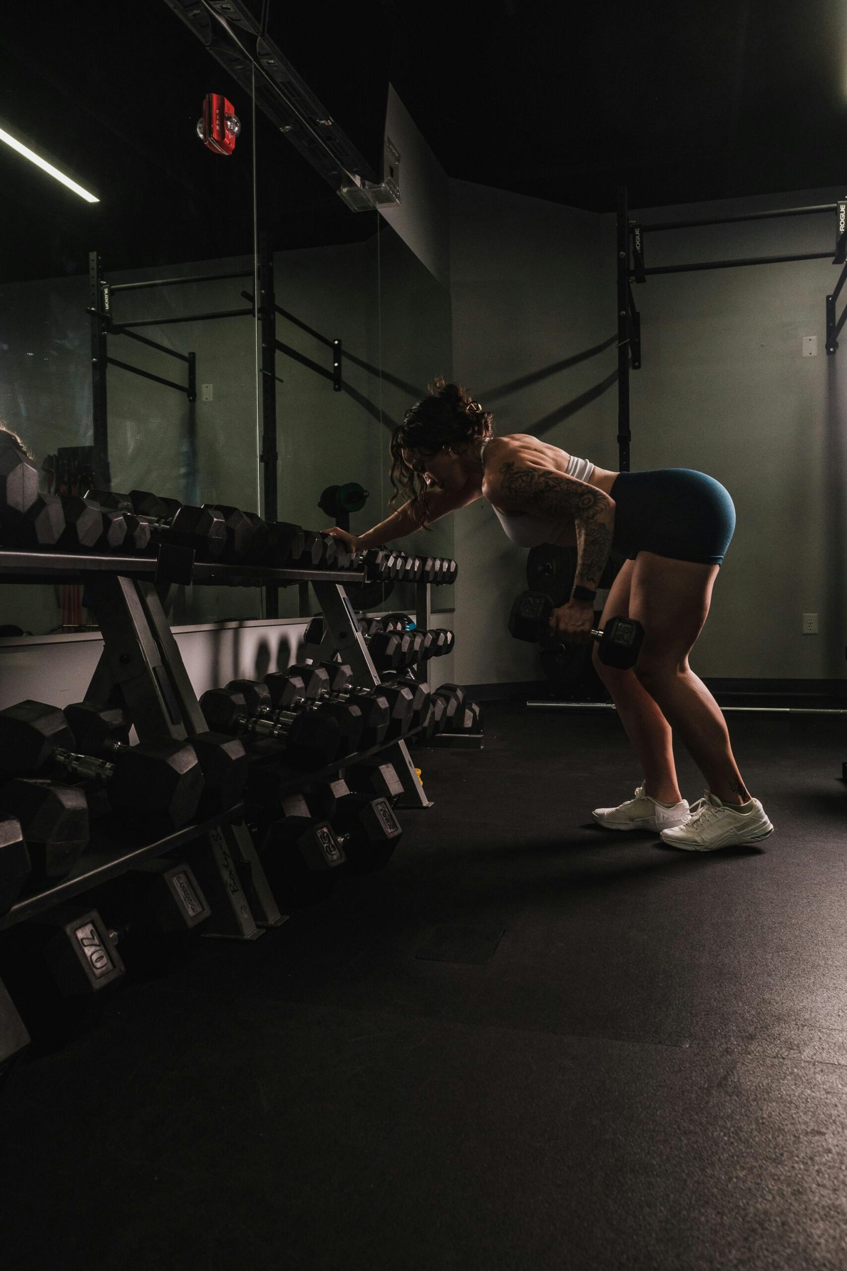 Mulher levantando pesos em uma academia.